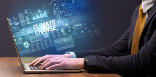 Businessman working on laptop with CLIMATE CHANGE inscription, cyber technology concept