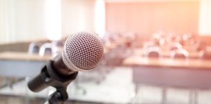 Microphone on abstract blurred of speech in seminar room