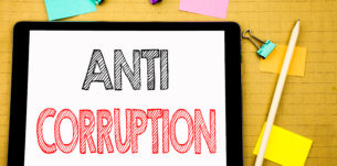 Word, writing Anti Corruption. Business concept for Bribery Corrupt Text Written on laptop, wooden background with sticky note and pen